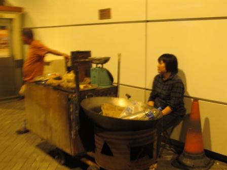 A street hawker is waiting for the time to start her day